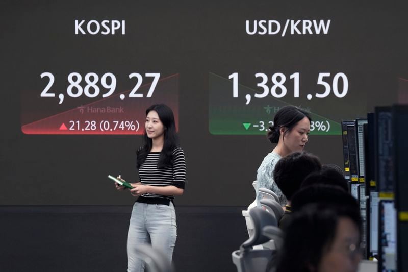 Currency traders work near the screen showing the Korea Composite Stock Price Index (KOSPI), left, and the foreign exchange rate between U.S. dollar and South Korean won at the foreign exchange dealing room of the KEB Hana Bank headquarters in Seoul, South Korea, Thursday, July 11, 2024. (AP Photo/Ahn Young-joon)