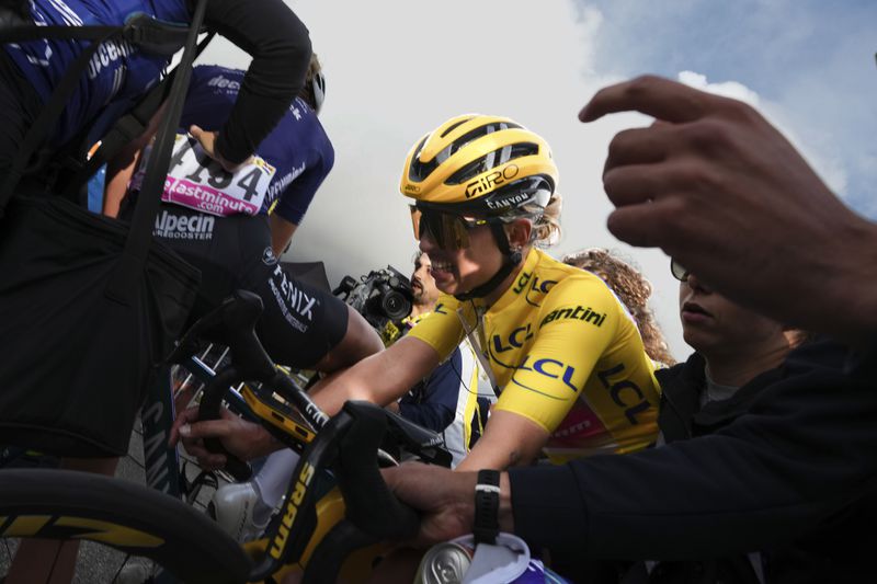 Overall winner Katarzyna Niewiadoma of Poland crosses the finish line to retain her yellow jersey in the eighth stage of the Tour de France Women cycling race with start in Le Grand-Bornand and finish in Alpe d'Huez, France, Sunday, Aug. 18, 2024. (AP Photo/Peter Dejong)