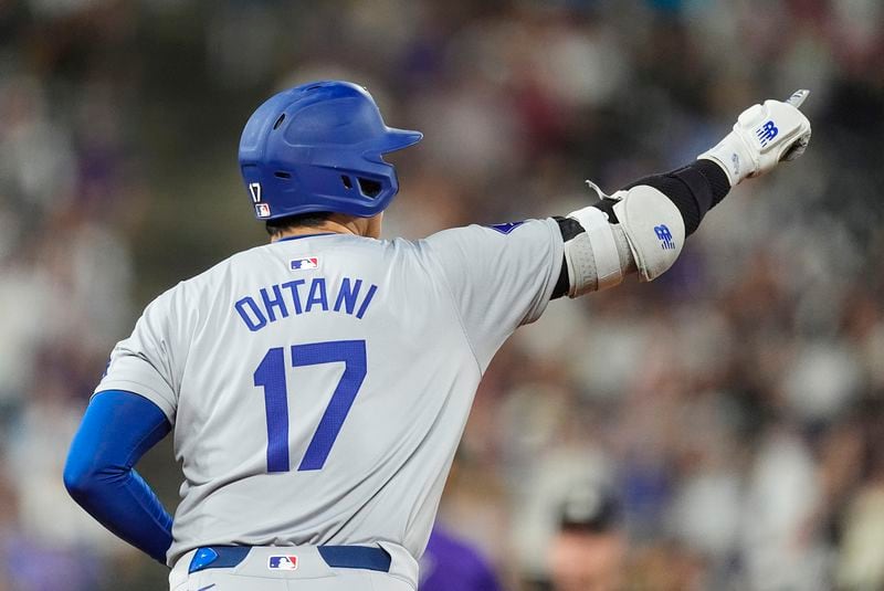 Los Angeles Dodgers' Shohei Ohtani gestures to the bullpen as he circles the bases after hitting a three-run home run off Colorado Rockies relief pitcher Anthony Molina in the sixth inning of a baseball game Friday, Sept. 27, 2024, in Denver. (AP Photo/David Zalubowski)