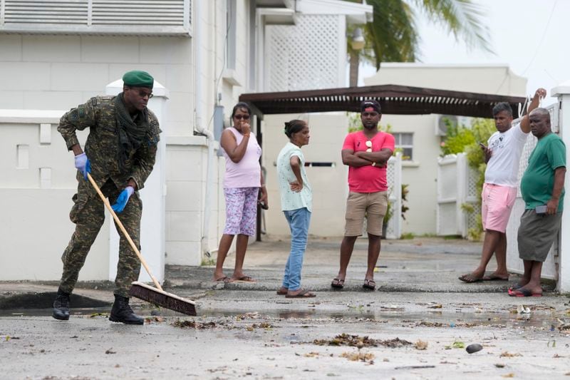 A Barbados Defence Force member cleans up a street after Hurricane Beryl passed through Oistins, Barbados, Monday, July 1, 2024. (AP Photo/Ricardo Mazalan)