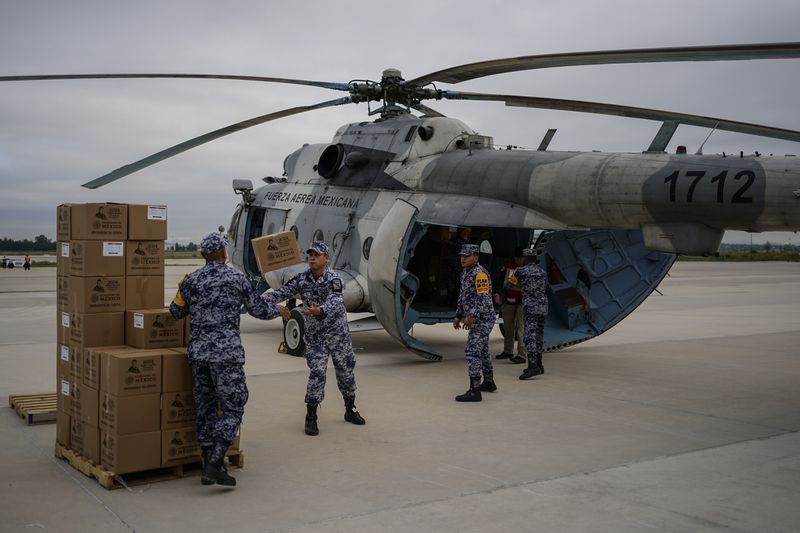 Mexican Air Force officers pack food for victims of Hurricane John, which hit the state of Guerrero, in Mexico City, Monday, Sept. 30, 2024. (AP Photo/Felix Marquez)