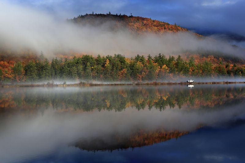 FILE - A railroad worker inspects the tracks behind his truck alongside the Androsscoggin River as a storm clears to reveal colorful fall foliage, Oct. 29, 2015, near Gorham, N.H. (AP Photo/Robert F. Bukaty, File)