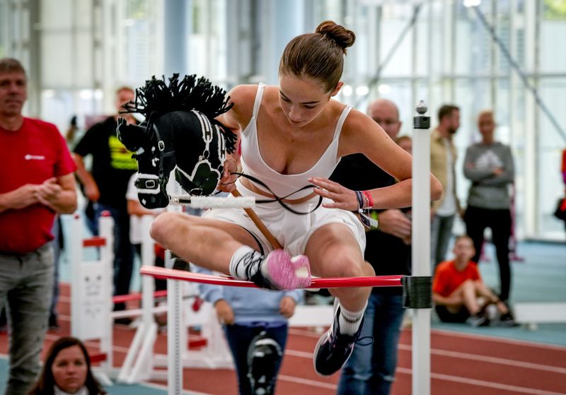 A girl clears the bar during the first German Hobby Horsing Championship in Frankfurt, Germany, Saturday, Sept. 14, 2024. (AP Photo/Michael Probst)