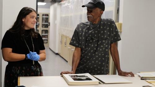 Emory University intern Anna Clark and Tom Dorsey with Dorsey's collection of black-and-white photographs of the West Side of Chicago. 'A Very Incomplete Self-Portrait: Tom Dorsey's Chicago Portfolio' is at the Michael C. Carlos Museum through July 16. Photo courtesy of the Carlos Museum.