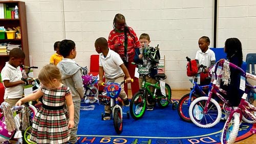 Early Learning Center at Henderson E. Formey School Principal, Erica Swindell-Foster helps Pre-K and Kindergarten students test out donated bikes from Gateway Terminals on Thursday Dec. 14, 2023