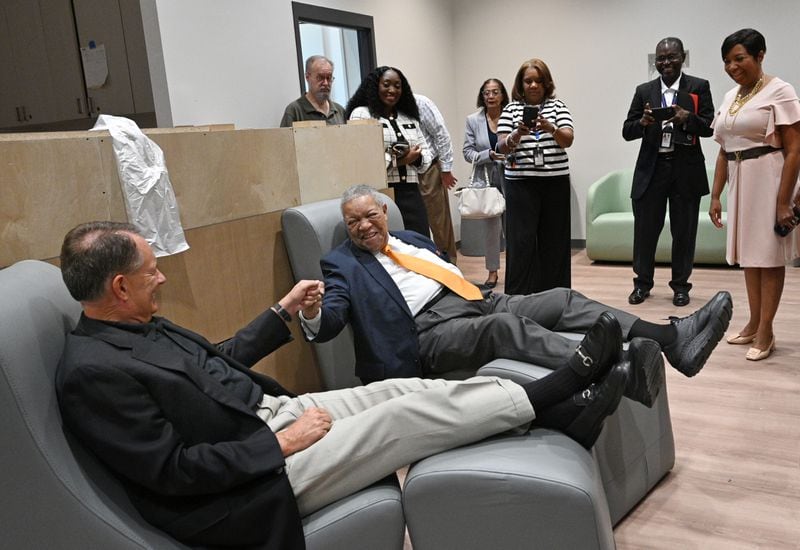 Fulton County Manager Dick Anderson (left) gets a fist bump from Fulton Commission Chairman Robb Pitts as they sit on furniture designed for the center’s clients during a facility tour lead by LaTrina Foster (not pictured), director of Behavioral Health, at the new Fulton County Behavioral Health Crisis Center. (Hyosub Shin / AJC)