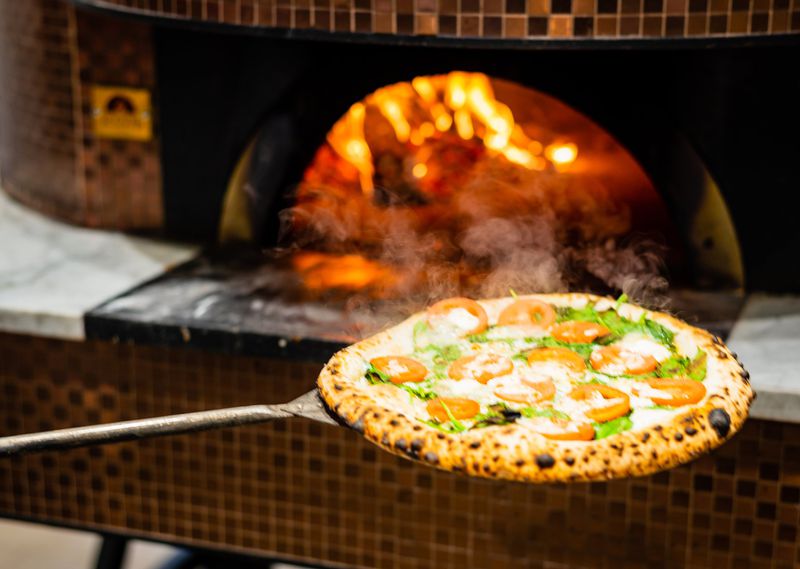 A Pesto Gorgonzola pizza comes out of the oven at Ammazza. CONTRIBUTED BY HENRI HOLLIS