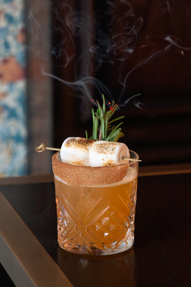 A toasty marshmallow garnish and hints of campfire from smoked rosemary turn the dart room atmosphere of Flight Club instantly toward fall when sipping the bourbon campfire cider. 
Courtesy of Fight Club