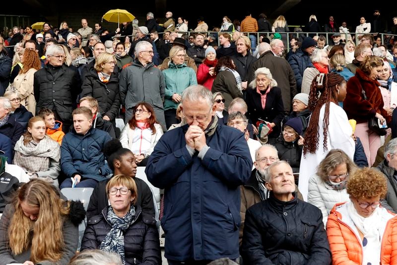 A faithful prays as Pope Francis presides the holy mass , at the King Baudouin stadium in Brussels, Belgium, Sunday, Sept. 29, 2024. (AP Photo/Omar Havana)