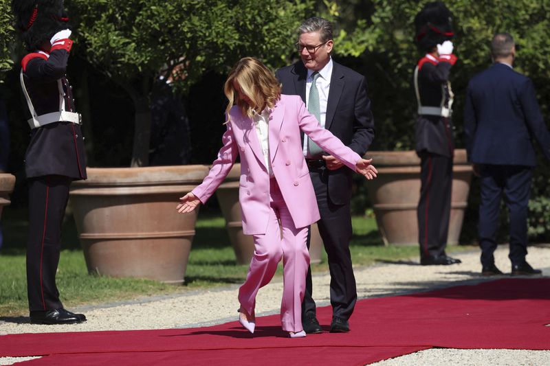 Italian Prime Minister Giorgia Meloni indicates to British Prime Minister Keir Starmer where to stand on the occasion of their meeting at Villa Doria Pamphilj in Rome, Monday, Sept. 16, 2024. (Phil Noble/Pool Photo via AP)