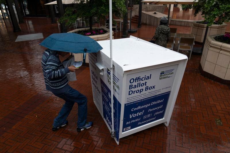 A person drops off their vote-by-mail ballot at a dropbox in Pioneer Square during primary voting on Tuesday, May 21, 2024, in Portland, Ore. (AP Photo/Jenny Kane)