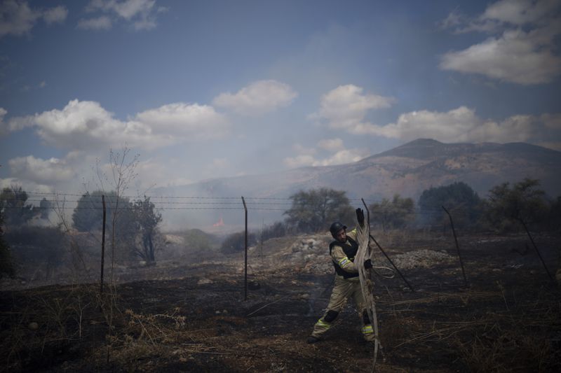 An Israeli firefighter works to extinguish a fire burning in an area, following an attack from Lebanon, near the Kibbutz Snir, northern Israel, Monday, Sept. 16, 2024. (AP Photo/Leo Correa)