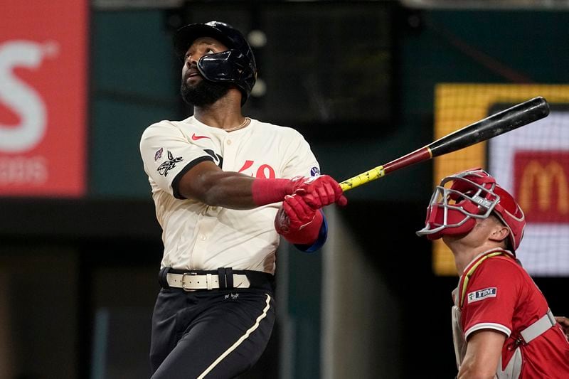 Texas Rangers' Sandro Fabian follows through on a fly out to right, as Los Angeles Angels catcher Logan O'Hoppe looks on in the second inning of a baseball game, Friday, Sept. 6, 2024, in Arlington, Texas. (AP Photo/Tony Gutierrez)