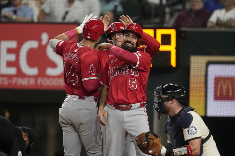 Los Angeles Angels' Anthony Rendon (6), Logan O'Hoppe (14) and Mickey Moniak, center back, celebrate after Hoppe's three-run home run scored them as Texas Rangers catcher Carson Kelly, right, kneels by the plate in the sixth inning of a baseball game Friday, Sept. 6, 2024, in Arlington, Texas. (AP Photo/Tony Gutierrez)