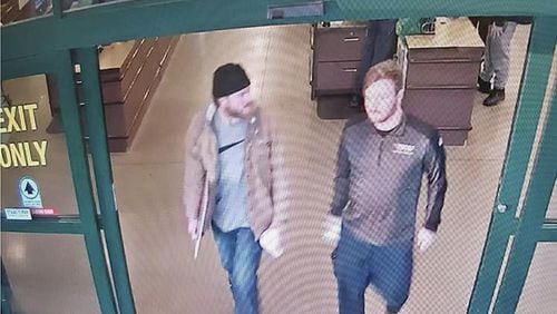 In this file image from a Jan. 1 surveillance video released by the U.S. Attorney's Office in Maryland, Brian Mark Lemley Jr., right, and Patrik Mathews leave a store in Delaware where they purchased ammunition and paper shooting targets. The pair, along with William Garfield Bilbrough IV, were arrested in January and are accused of plotting to commit violence at a Virginia gun rights rally.