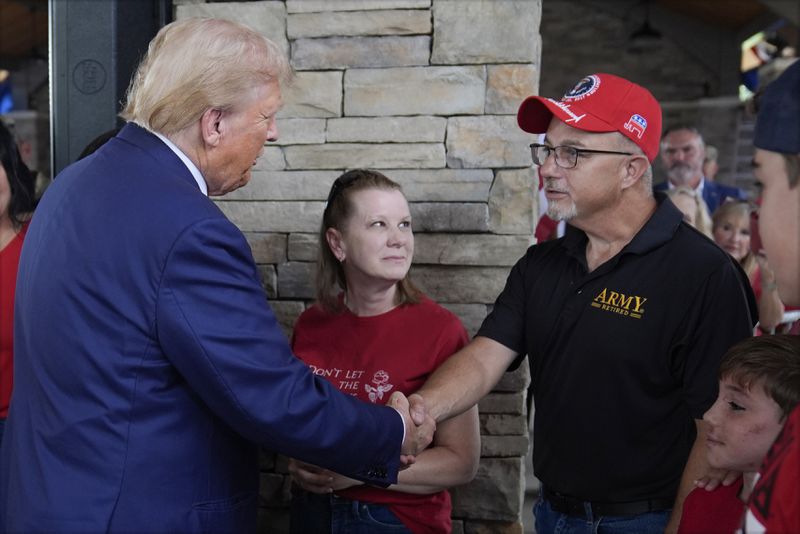 Republican presidential nominee former President Donald Trump greets people at a temporary relief shelter as he visits areas impacted by Hurricane Helene, Friday, Oct. 4, 2024, in Evans, Ga. (AP Photo/Evan Vucci)