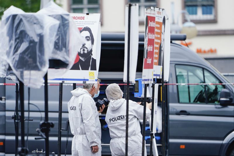 A forensic police officers work at the scene of a knife attack at the market square in Mannheim, Germany, Friday, May 31, 2024. An assailant with a knife attacked and wounded several people in a central square in the southwestern German city of Mannheim on Friday, police said. Police shot the attacker, who also was hurt. (Uwe Anspach/dpa via AP)