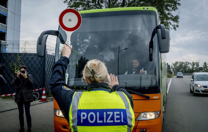 A German police officer stops a bus at the border between Germany and France in Kehl, Germany, Monday, Sept. 16, 2024, as Germany begins carrying out checks at all its land borders. (AP Photo/Michael Probst)