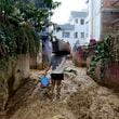 A man walks on a muddy alleyway carrying belongings salvaged from his house in Kathmandu, Nepal, Monday, Sept. 30, 2024 in the aftermath of a flood caused by heavy rains. (AP Photo/Gopen Rai)