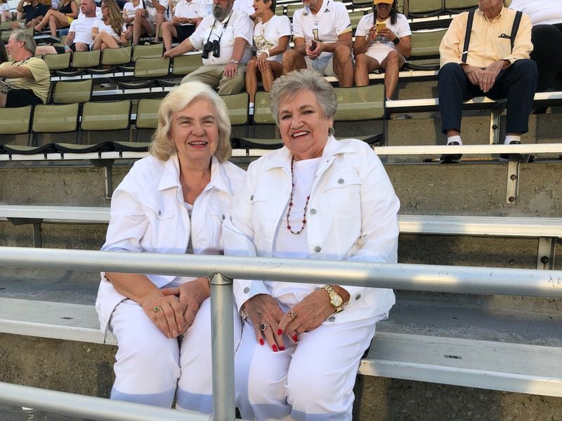 Georgia Tech season-ticket holder Shirley Plunkett (left) sits with close friend Laura Strickland at Bobby Dodd Stadium before the Yellow Jackets' season opener against Northern Illinois on Sept. 4, 2021. This is the 36th consecutive year that Plunkett, from Bowdon, has held season tickets. Both were dressed for Tech's annual whiteout game. (AJC photo by Ken Sugiura)