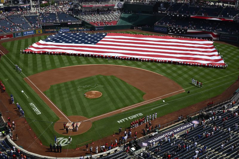 An American flag is displayed on the field before a baseball game between the Washington Nationals and the New York Mets, Thursday, July 4, 2024, in Washington. (AP Photo/Nick Wass)
