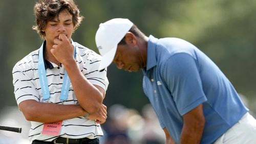 Tiger Woods putts as his son, Charlie watches on the 18th hole during a practice round for the U.S. Open golf tournament Monday, June 10, 2024, in Pinehurst, N.C. (AP Photo/Matt York)