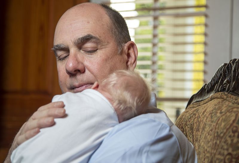 Beatty D’Alessandro cradles his three-week-old grandson Dominic “Beatty” at their residence in Duluth. (Alyssa Pointer / Alyssa.Pointer@ajc.com)