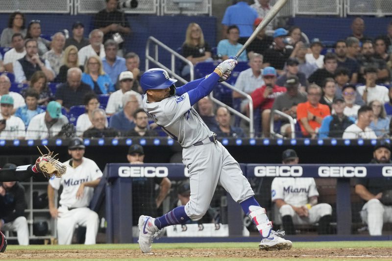 Los Angeles Dodgers' Mookie Betts (50) a triple to center field during the fifth inning of a baseball game against the Miami Marlins, Tuesday, Sept. 17, 2024, in Miami. (AP Photo/Marta Lavandier)