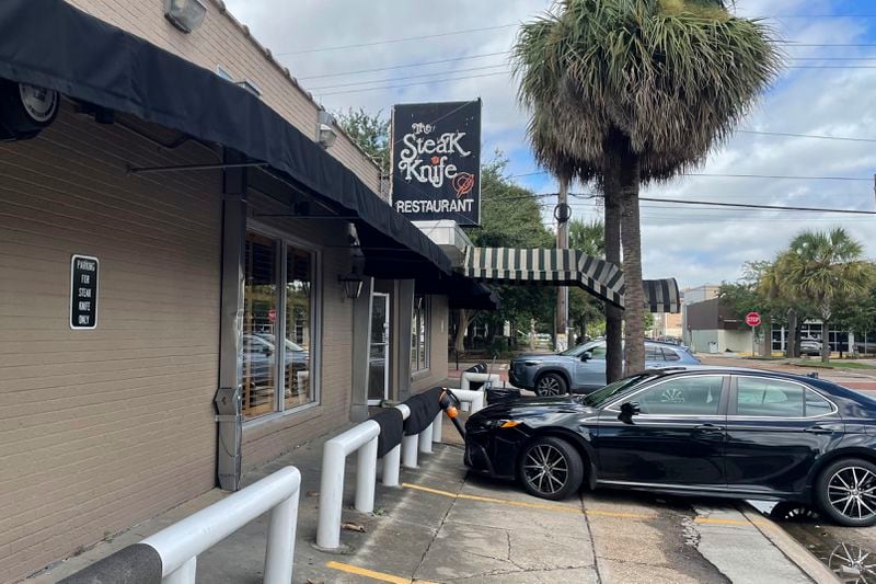 Floor mats from inside The Steak Knife, a New Orleans restaurant, are hung out to dry on parking barriers after Hurricane Francine passed over the city the night before, Thursday, Sept. 12, 2024. (AP Photo/Brett Martel)