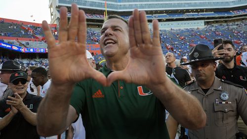 Miami head coach Mario Cristobal makes the sign of the U to cheering fans as he leaves the field after defeating Florida in an NCAA college football game, Saturday, Aug. 31, 2024, in Gainesville, Fla. (AP Photo/John Raoux)