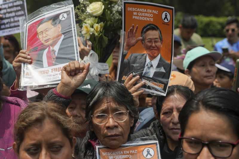 Supporters of former President Alberto Fujimori gather outside the cemetery during his funeral in Lima, Peru, Saturday, Sept. 14, 2024. (AP Photo/Guadalupe Pardo)