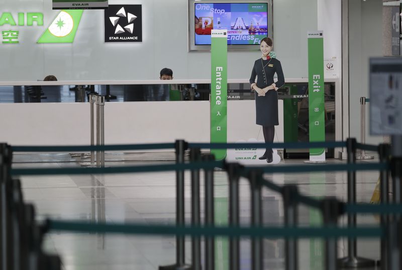 Airline staff work at the counter at a closed airport due to approaching Typhoon Krathon, in Kaohsiung, southern Taiwan, Wednesday, Oct. 2, 2024. (AP Photo/Chiang Ying-ying)