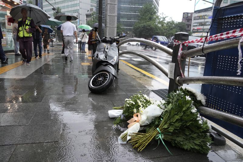 Flowers are placed at a car accident scene near Seoul City Hall in downtown Seoul, South Korea, Tuesday, July 2, 2024. A car hit several people Monday night, after reportedly going in the wrong direction and colliding with two other cars killing multiple people. The driver will be investigated on allegations of accidental homicide, police said Tuesday. (AP Photo/Ahn Young-joon)