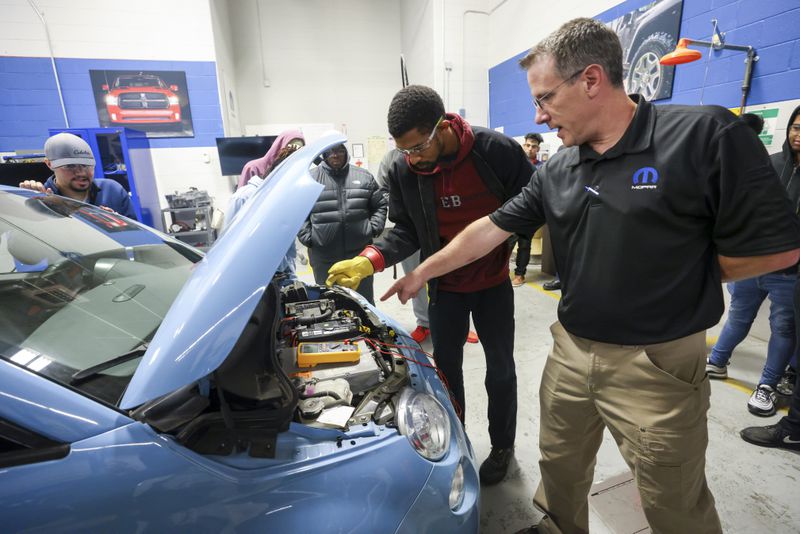 MOPAR CAP program director Andy Lindman (right) instructs automotive technology student Michael Cheek of Lilburn as he performs a safety demonstration on a Fiat 500e in the EV Automotive Lab at Gwinnett Technical College, Wednesday, Oct. 18, 2023, in Lawrenceville. (Jason Getz / Jason.Getz@ajc.com)
