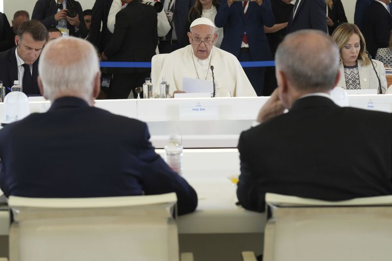 Pope Francis speaks during a working session on Artificial Intelligence (AI), Energy, Africa-Mediterranean, on day two of the 50th G7 summit at Borgo Egnazia, southern Italy, on Friday, June 14, 2024. U.S. President Joe Biden is seen with back to camera at left, and Turkish President Recep Tayyip Erdogan at right. (Christopher Furlong/Pool Photo via AP)