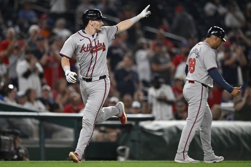 Atlanta Braves' Sean Murphy runs home past Braves third base coach Matt Tuiasosopo after hitting two-run home run during the sixth inning of a baseball game against the Washington Nationals, Tuesday, Sept. 10, 2024, in Washington. (AP Photo/John McDonnell)