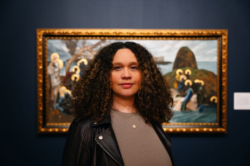 Spelman College Museum of Fine Art Executive Director Liz Andrews in front of a painting by Afro-Cuban American artist Harmonia Rosales during Rosales' Master Narratives exhibit last November. (Olivia Bowdoin for the Atlanta Journal-Constitution).  