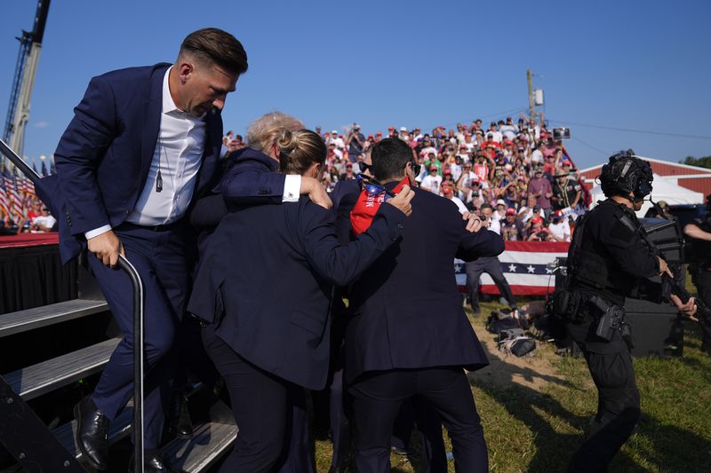 Republican presidential candidate former President Donald Trump is surrounded by U.S. Secret Service agents at a campaign rally, Saturday, July 13, 2024, in Butler, Pa. (AP Photo/Evan Vucci)