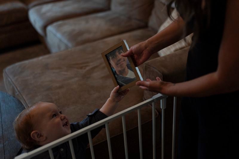 Mikayla Brown, right, shows a photo of Elijah Ott, who died of a fentanyl overdose at 15, to her youngest son, Crew, at their home in Atascadero, Calif., Friday, Aug. 2, 2024. (AP Photo/Jae C. Hong)