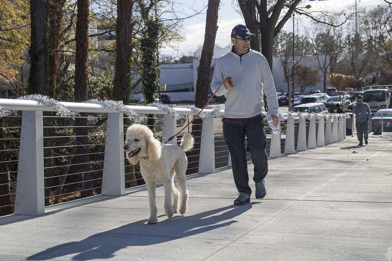 Brookhaven resident Richard Schepp walks his dog Jeter along the newly developed Peachtree Creek Greenway on Dec. 12, 2019. The mile-long stretch doesn’t go anywhere right now, but could eventually link up with Atlanta’s PATH400, another growing route that could someday connect the Greenway to the Beltline and to Dunwoody and points beyond. ALYSSA POINTER / ALYSSA.POINTER@AJC.COM