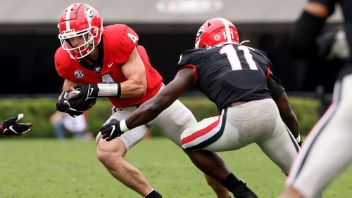 Georgia tight end Oscar Delp (4) tries to run away from linebacker Jalon Walker (11) during the G-Day game at Sanford Stadium on Saturday, April 16, 2022, in Athens, Ga. (Jason Getz / Jason.Getz@ajc.com)