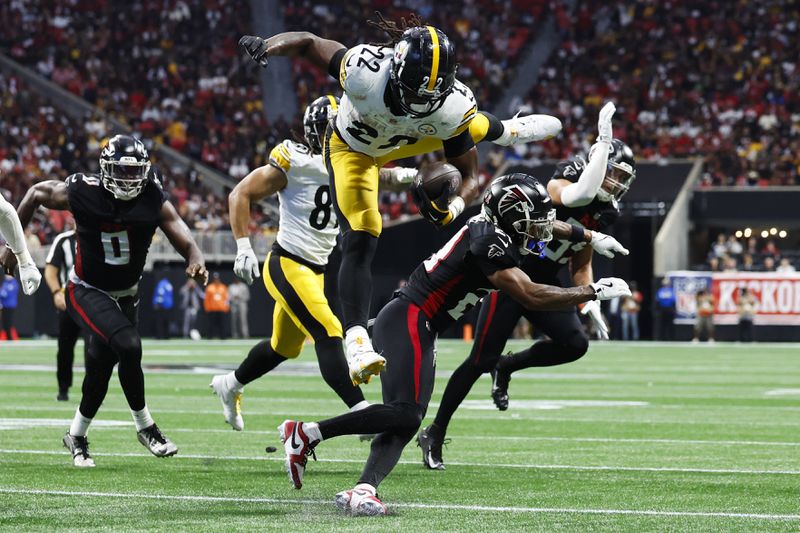 Pittsburgh Steelers running back Najee Harris (22) jumps over Atlanta Falcons cornerback Mike Hughes (21) during the second half of an NFL football game Sunday, Sept. 8, 2024, in Atlanta. (AP Photo/Butch Dill)