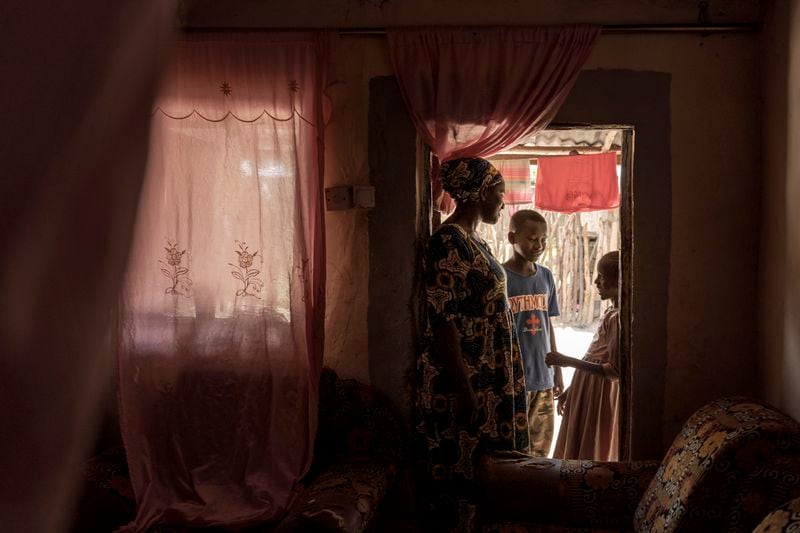 Musukebbe Manjang, left, speaks with her son Boubacar Darbo, center, and his sister Fatima in the village of Kwinella, Gambia, on July 27, 2024. (AP Photo/Annika Hammerschlag)