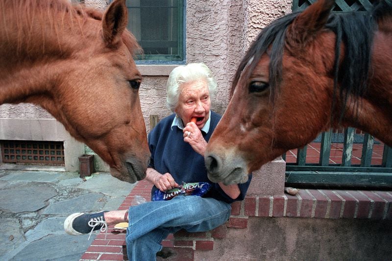 Sandy West halves a carrot to give to her horses Poca Di Diablo (l) and Cela (r) on her back doorstep on Nov. 9, 1999. LEVETTE BAGWELL / THE ATLANTA JOURNAL-CONSTITUTION