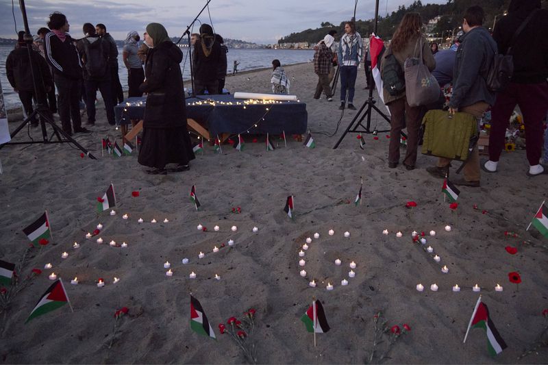 Ezgi is spelled in candles on the sand during a vigil on Alki Beach for Aysenur Ezgi Eygi, a 26-year-old activist from Seattle, who was killed recently in the West Bank, Wednesday, Sept. 11, 2024, in Seattle. (AP Photo/John Froschauer)