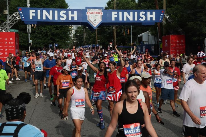 Colette Pointer and Lynette Huddle pose at the finish of the 55th running of the Atlanta Journal-Constitution Peachtree Road Race in Atlanta on Thursday, July 4, 2024.   (Jason Getz / AJC)