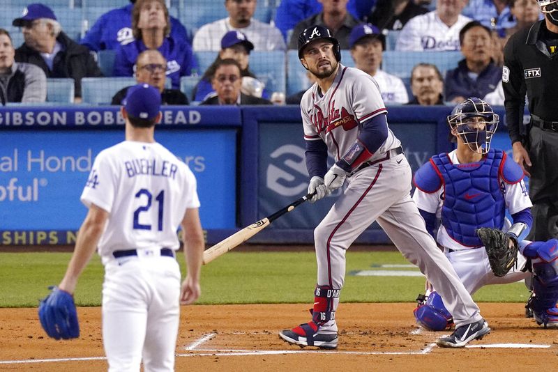 Atlanta Braves' Travis d'Arnaud, center, heads toward first after hitting a solo home run as Los Angeles Dodgers starting pitcher Walker Buehler, left, and catcher Austin Barnes watch during the second inning of a baseball game Tuesday, April 19, 2022, in Los Angeles. (AP Photo/Mark J. Terrill)