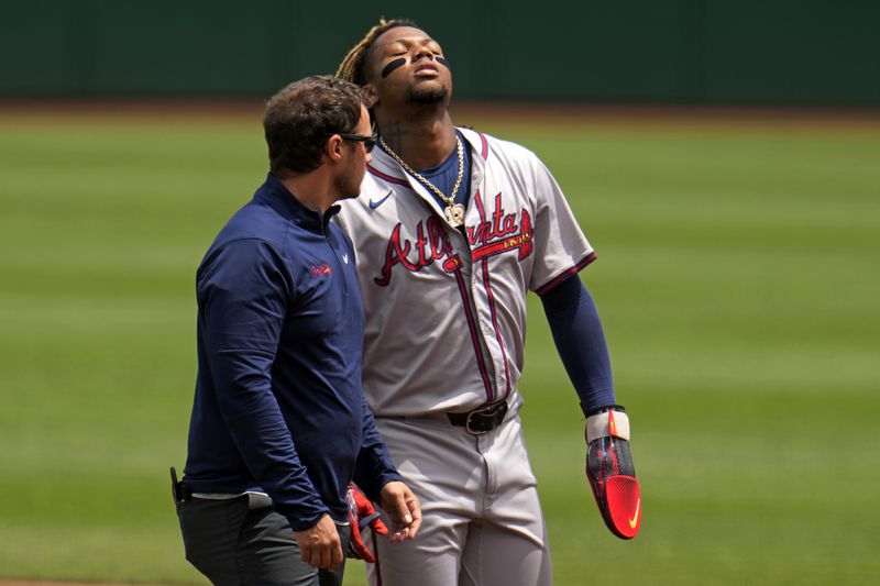 FILE - Atlanta Braves' Ronald Acuña Jr., right, walks off the field with a trainer after being injured while running the bases during the first inning of a baseball game against the Pittsburgh Pirates in Pittsburgh, Sunday, May 26, 2024. (AP Photo/Gene J. Puskar, File)