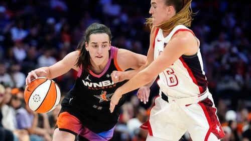 Caitlin Clark, left, of Team WNBA, dribbles against Sabrina Ionescu (6), of Team USA, during the second half of a WNBA All-Star basketball game Saturday, July 20, 2024, in Phoenix. (AP Photo/Ross D. Franklin)