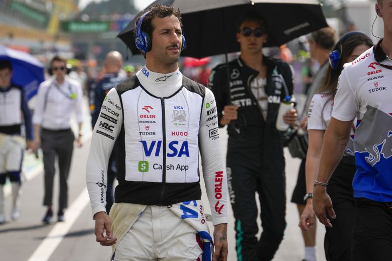 RB Daniel Ricciardo of Australia walks to the starting grid before the Formula One Italian Grand Prix race at the Monza racetrack, in Monza, Italy, Sunday, Sept. 1, 2024. (AP Photo/Luca Bruno)